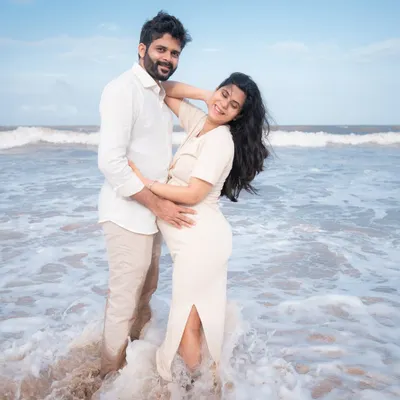 A playful moment captured as the waves crash around the happy couple. Their joy is so infectious, and the beach setting adds a feeling of freedom and fun to their maternity portraits.