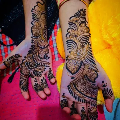 A bold and beautiful Arabic mehandi design. This style is characterized by thick, dark outlines and flowing patterns that create a striking look on the back of the hand.