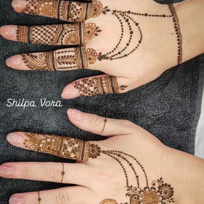 A beautiful example of a modern fusion design, combining detailed finger work with a delicate 'hathphool' (hand jewelry) style pattern on the back of the hand.