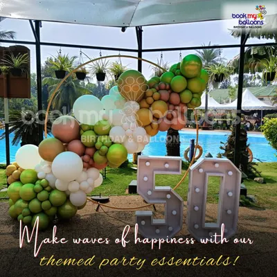 This poolside 50th milestone celebration shows our expertise in outdoor decor. The arrangement features a circular frame with a balloon garland in olive green, brown, and white, paired with large marquee numbers, designed to be stable and visually striking in an open-air setting.