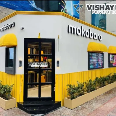 This is the finished Mokobara pop-up store in Gurugram, a project I'm very proud of. Notice the bright yellow paneling, backlit 3D logos, and warm exterior lighting that make it inviting for evening shoppers. This is a prime example of a high-impact portable retail solution.