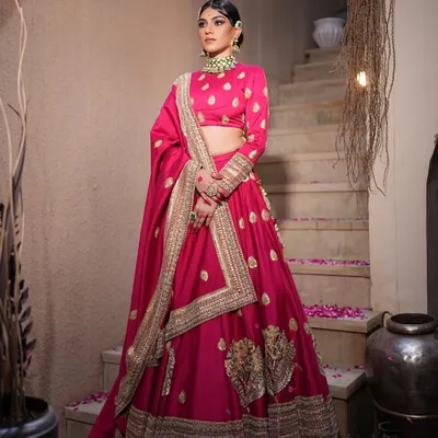 A stunning fuchsia pink lehenga styled for a festive look. I paired it with traditional Kundan jewelry and a sleek bun adorned with a red rose for a touch of classic romance.