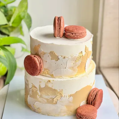 For a dad who deserves nothing but timeless elegance. This minimal, modern two-tier cake features a textured buttercream finish with gold leaf accents and is adorned with delicious macarons.