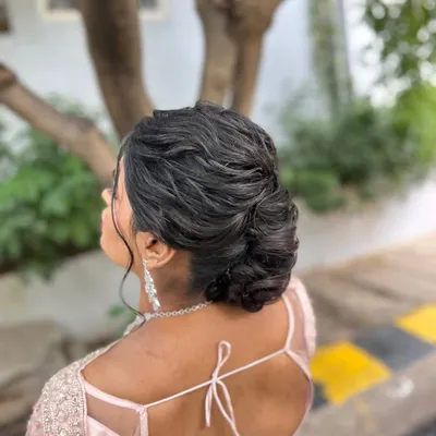 A soft, textured low bun with gentle wisps framing the face, creating a romantic and effortless look.