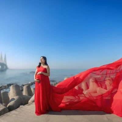 A beautiful maternity shoot against the iconic Mumbai sea link. Our classic red trail gown is a popular choice for moms-to-be who want a bold and beautiful look.