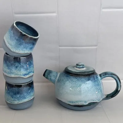 My light blue teapot and cup set, arranged to show the beautiful, frosty glaze. This wheel-thrown set is perfect for a peaceful afternoon tea.
