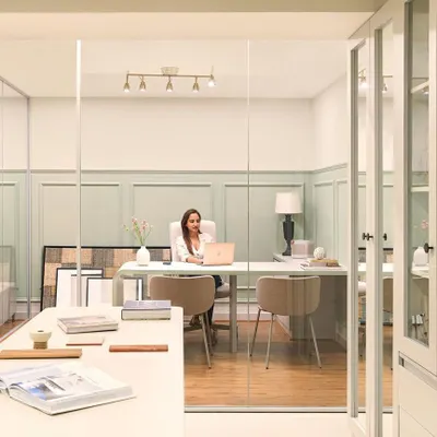 A view into my personal cabin at the Furbishy HQ. The space is designed with glass walls to maintain a sense of openness, while the soft green wall paneling and clean, modern desk create a calm and inspiring work environment.