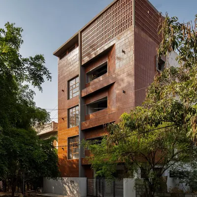 A full view of Project 723's facade, showcasing the use of linear bricks in both soldier and stretcher bonds. The arrangement creates a textured, monolithic appearance, punctuated by recessed windows and balconies.