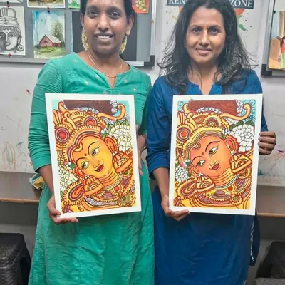 Two of our students proudly holding their completed Kerala mural paintings. It's amazing to see how each artist brings their own unique touch to the same traditional subject.