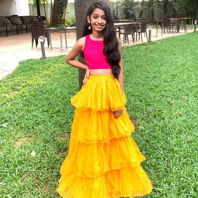 This is one of my favorite bold and bright creations. The vibrant yellow tiered net skirt paired with a simple pink crop top makes for a fun, modern, and unforgettable party outfit.