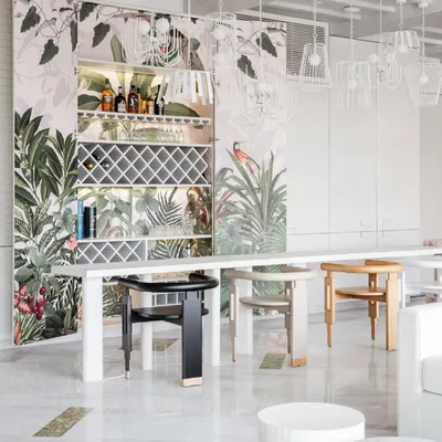 The 'Reveal Bar' from House No. 7 is a favorite piece. Clad in tone-on-tone paneling, it blends into the wall, but opens to reveal a paradise of Birds of Paradise wallpaper, transforming the space instantly.