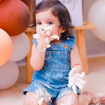 Getting every last bit of frosting! This close-up captures the pure delight of a baby's first cake smash. It's a memory full of sweetness and fun.