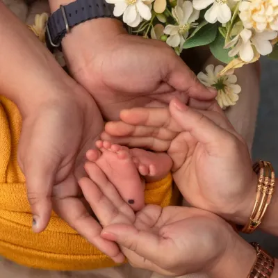 A classic and powerful shot of a newborn's tiny feet held safely in their parents' hands. This image speaks volumes about love, protection, and new beginnings.