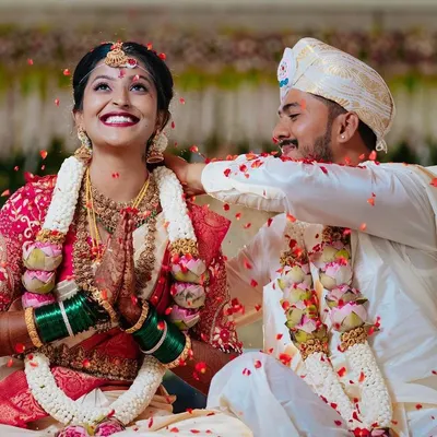 The sacred moment of the Mangalya Dharanam, where the groom ties the holy thread around the bride's neck. The shower of petals and the bride's joyful smile make this a truly cherished memory.
