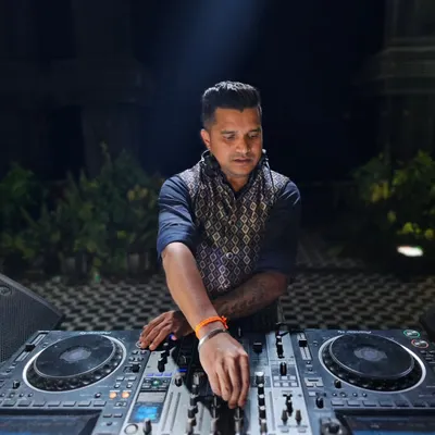 A close-up shot of me at the console during a night event. The focus is intense as I line up the next track to keep the energy flowing seamlessly.