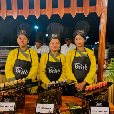 My team of sushi chefs, professionally dressed and ready to serve a variety of freshly made sushi rolls at the Japanese counter.