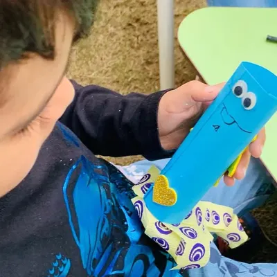A child proudly shows off the googly-eyed craft he made during our launch day event. I believe in providing activities that are not only fun but also give kids a sense of accomplishment.