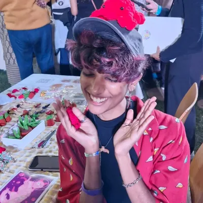 This is me, Lex, at an art market, overjoyed with the support from everyone. I'm wearing a crochet octopus on my hat, because why not?