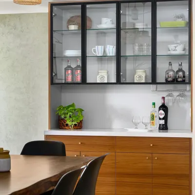 This crockery-cum-bar unit from our 'Wind-chime' project features black-framed glass shutters and a solid wood base, providing a sophisticated spot for dining storage and entertainment.