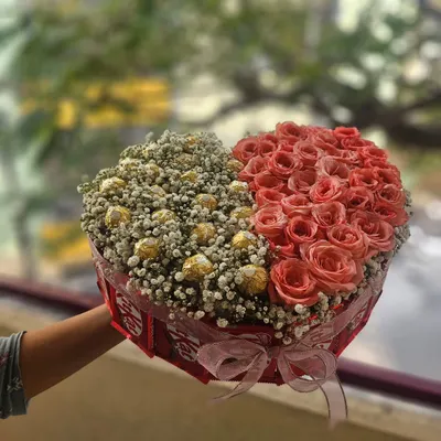 A stunning heart-shaped bouquet perfect for Valentine's Day or an anniversary. This arrangement is half fresh pink roses and half Ferrero Rocher chocolates nestled in baby's breath.