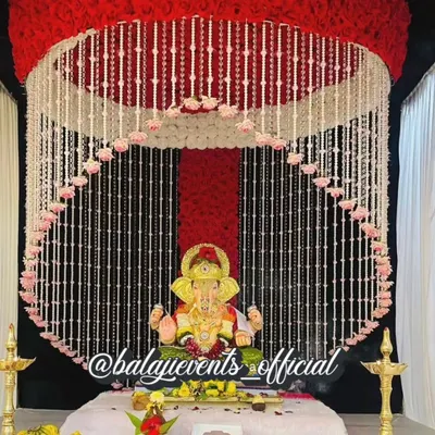 This ready-to-use artificial flower decoration set is available for sale and can be delivered across India. It includes a floral ring, backdrop, and all necessary accessories for an elegant gharguti Ganpati mandap.
