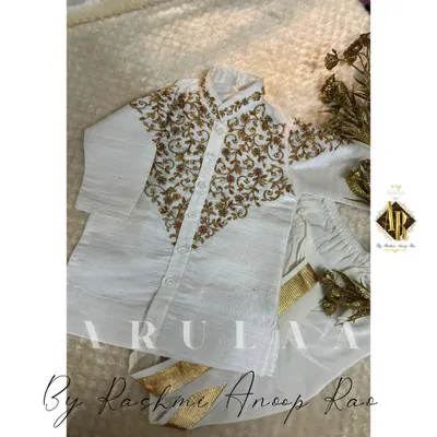 A complete traditional set for a toddler. This custom 'Jubba' and 'kacche' is made from off-white silk with delicate gold hand embroidery, perfect for a little one's first big ceremony.