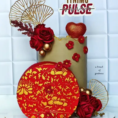 An elegant corporate cake designed for Tynimo Pulse. The sophisticated red, gold, and beige color scheme and intricate details make it a perfect centerpiece for a company celebration or brand event.