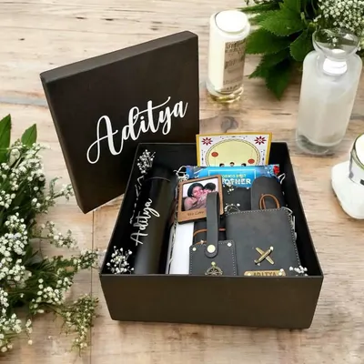 A thoughtfully curated gift box for 'Aditya', featuring a personalized tumbler, wallet, and keychain, along with a cherished photo to make it extra special.