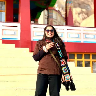 A happy customer staying warm and stylish on her travels with our classic black granny square muffler. We love seeing our creations become part of your adventures!