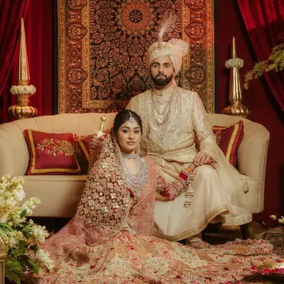 A portrait of royalty. This shot of Aashna and Akshay, posed against a lavish, regal backdrop, captures the grandeur and timelessness of a classic Indian wedding.