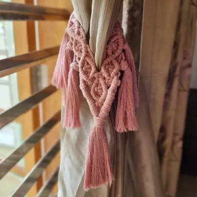 Transform your space with our handcrafted macrame curtain ties. This pink tie-back adds a touch of soft, boho chic to your window treatments.