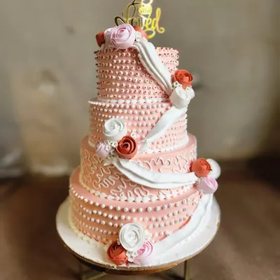 A grand four-tier cake celebrating 25 years of love. Each tier is intricately detailed with different piping techniques and adorned with handmade sugar flowers, making it a true centerpiece for a milestone anniversary.