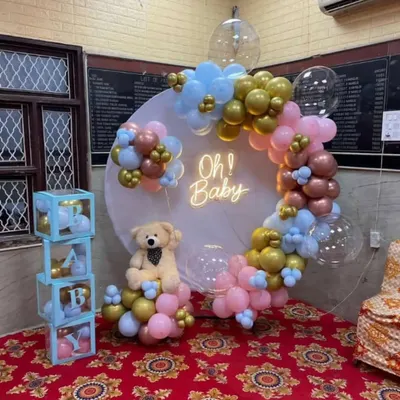 A classic 'Oh Baby' shower setup with a gender neutral color scheme. I used a round backdrop with a neon sign, a balloon garland in pink, blue, and gold, and a cute teddy bear prop.