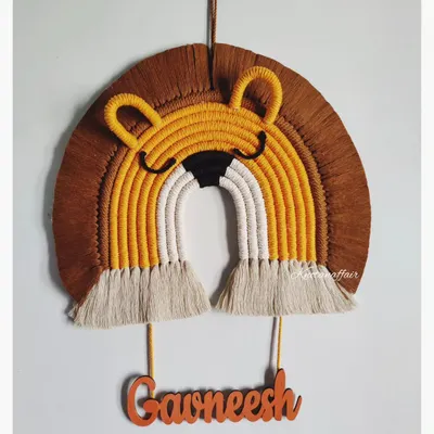This macrame lion face, made for a little one named Gawneesh, is one of my favorite designs for a kid's room. The mix of mustard, brown, and white cotton cords creates a friendly and playful character. I can add any name to make it a truly special and personal gift.
