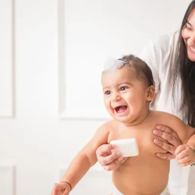 This shot from a baby skincare campaign is all about capturing pure joy. The baby's infectious laughter and the soft, clean lighting create a heartwarming image that speaks to a happy and healthy bathtime routine.