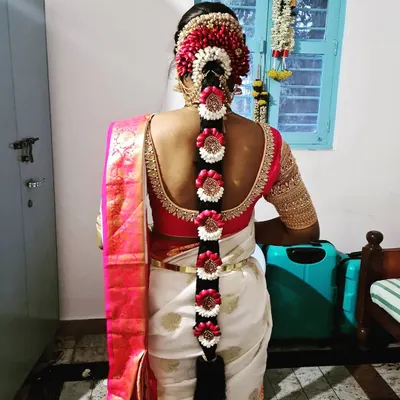 A stunning example of a traditional Poola Jada, or floral braid. This intricate design uses fresh flowers and is a classic choice for South Indian brides.