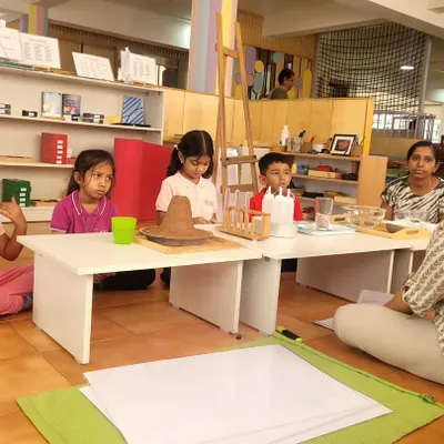 The wonder of science. The children are captivated by a demonstration of a volcano erupting. We use these exciting experiments to introduce concepts from our "Great Stories," like the story of the Earth's formation.