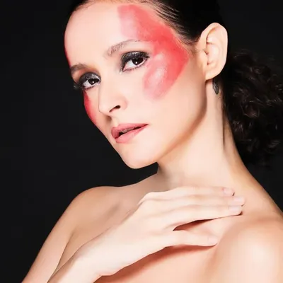 This image is part of a conceptual series exploring monochromatic themes. I used red pigment to paint bold, graphic shapes on the face, contrasting with a dark, smokey eye to create a visually arresting and artistic look.