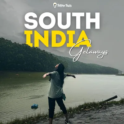 A woman stands with her arms wide open, overlooking a serene lake in the South Indian hills. This is the feeling of freedom and peace you get on my getaways.