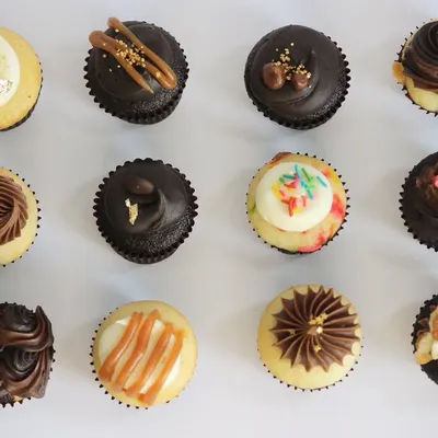An overhead shot displaying the full variety of TBC Minis you can find in an assorted box. Each one is decorated differently to reflect its unique flavour, from rich chocolate to Indian-inspired Kesar Pista.