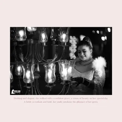A timeless black and white portrait of the bride, Deepakshi, her smile illuminated by the warm glow of a chandelier at the Grand Imperia.
