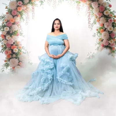 A breathtaking portrait in a ruffled, sky-blue gown. The floral arch and dreamy smoke effect create a fairytale scene right in the studio.