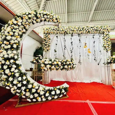 A wide-angle view of our signature crescent moon floral arrangement for a naming ceremony. This setup includes the large floral moon, a fully decorated cradle, and a matching floral backdrop, creating a dreamy and cohesive look.