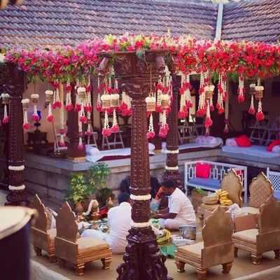 I love bringing a traditional mandap to life in a heritage setting. Here, at a 240-year-old Thottimane, we used antique wooden pillars, bougainvillea, and hanging floral strings to create a sacred and beautiful space.