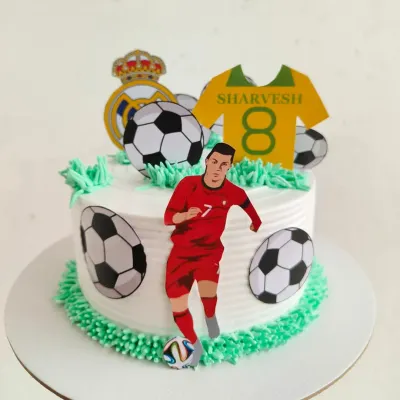A cake for a true Cristiano Ronaldo fan! This CR7 themed cake features the football star, soccer balls, and a jersey with the birthday boy's name and age.
