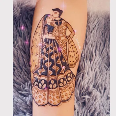 A romantic portrait of the bride and groom, capturing a sweet moment. This full-figure design on the forearm is a centerpiece of the bridal mehendi.