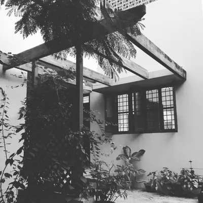 A quiet corner of a house I designed in Pune, featuring a wooden pergola that creates a gentle transition between indoor and outdoor space. This design element provides shade while allowing natural light and greenery to become part of the living experience.