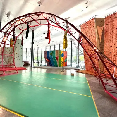 We are so grateful for this beautiful space. This wide shot shows our main training area, including the red arch, various climbing walls, and the open green floor where our parkour classes take place.