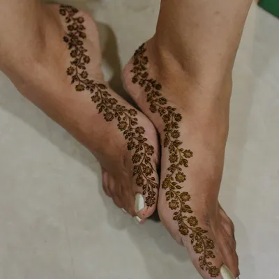 For the minimalist bride, a simple yet stunning floral vine that gracefully trails along the side of the foot. It's delicate, elegant, and timeless.