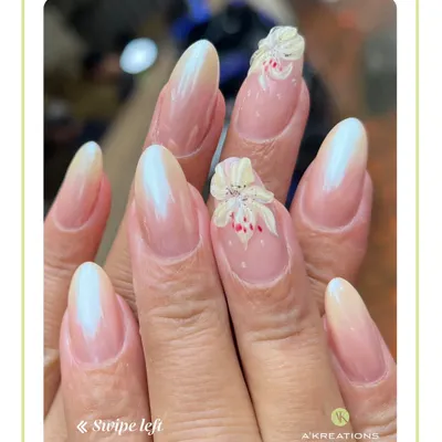 A subtle and elegant design featuring an ombre French manicure on almond-shaped nails, accented with a delicate, hand-sculpted 3D white flower.